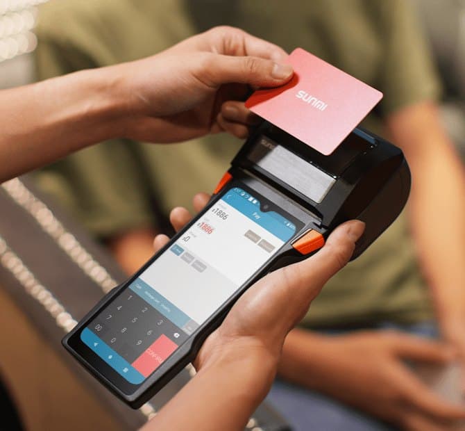 A customer paying by card on a handheld SortPi terminal